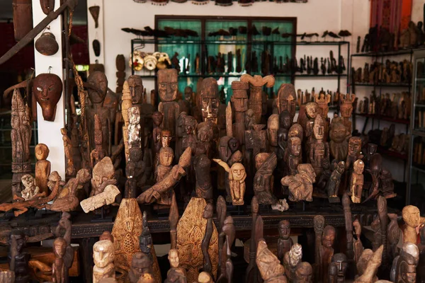 Wooden statues made from wood. Souvenir decoration, carving, and figurines from Indonesia. Typical souvenir shop selling souvenirs and handicrafts of Bali at the famous Ubud Market. Famous souvenirs