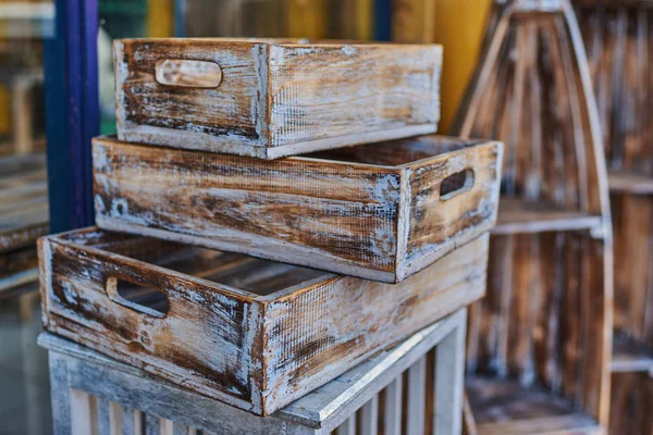 View of a furniture of drawers. Shabby vintage style interior, furniture from rustic whitened wood. Wooden drawers made of natural wood with handles and shelves of untreated wood for sale.
