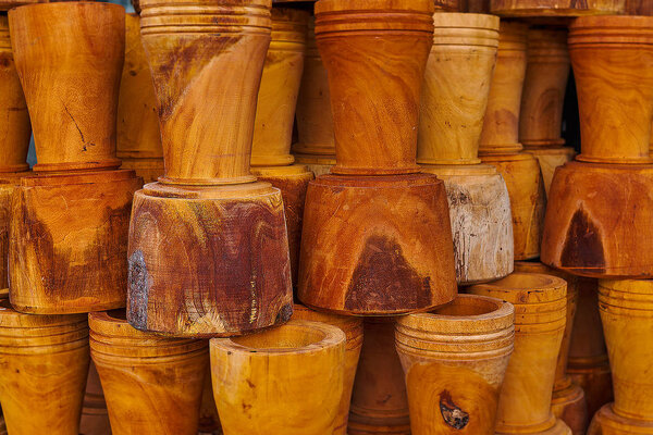 Wooden flower pots from natural wood in the market. Handmade souvenirs. Craft eco product of untreated wood for sale. Wooden crafts on a stall in the market. Walnut handmade wood flower pots.