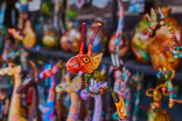 Colorful souvenir background. Souvenir shop selling souvenirs and handicrafts. Handmade wooden giraffe. Sale of souvenirs. Funny giraffes with bright colorful patterned. Selective focus.