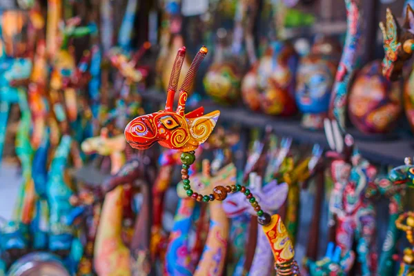 Colorful souvenir background. Souvenir shop selling souvenirs and handicrafts. Handmade wooden giraffe. Sale of souvenirs. Funny giraffes with bright colorful patterned. Selective focus.