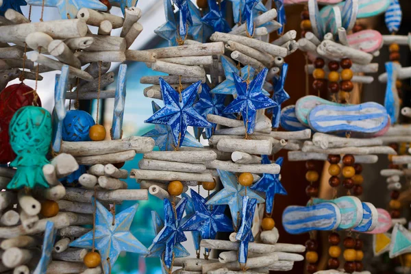 Souvenir background. Travel and tourism concept. Hanging handicraft decoration wooden carved toys. Art and craft market. Display of handicraft decoration in the open market. Selective focus.