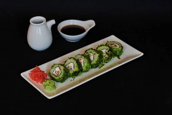 寿司卷寿司配虾 奶油芝士 日本料理 健康的甘蓝和鳄梨寿司卷用筷子 在黑暗背景下的寿司 芥末和姜 — 图库照片