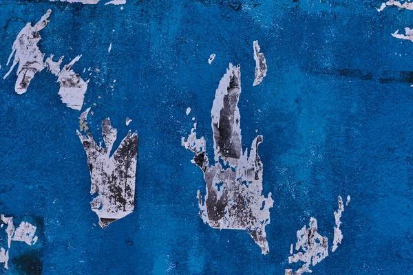 Зернистая Цементная Стена Оштукатурена Окрашена Синий Цвет Остатками Рваной Бумаги — стоковое фото