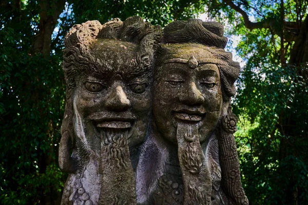 Traditional Balinese stone sculpture art and culture at Bali, Indonesia. Ancient stone sculpture. Temple with traditional stone sculpture.   Ancient old  statue covered with moss. Abstract background.