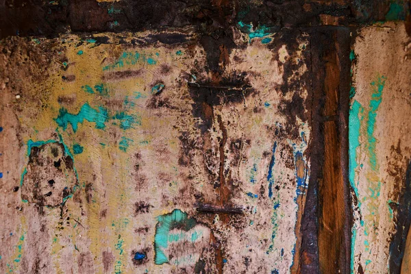 Multicolored background: rusty metal surface with white, green and brown paint flaking and cracking texture. Old worn metal surface.  Background. Metal. Wall. Rusty metal surface with cracked paint.