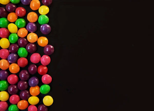 黒い背景に分類された色のキャンディー コピー スペース平面図 — ストック写真