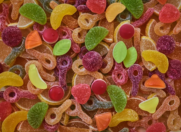 Various colorful  gummy candies use as background, top view. Colorful bright assorted  candy  and rainbow  jelly sweet.  An assortment of colorful jelly and sugar sweets. Top view. Candy background.