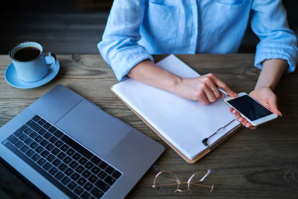 Business woman holding a pen in his hand, and signed a contract, note list, business document working, paperwork document and smart phone technology working together concept. Selective focus.