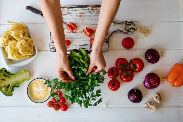 Top view womam hands. Food background. Food concept. Various fresh Ingredients for cooking. Picture of kitchen table with colorful vegetables . Sliced vegetables for making meal. Selective focus.