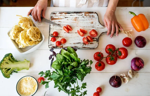 Top view womam hands. Food background. Food concept. Various fresh Ingredients for cooking. Picture of kitchen table with colorful vegetables . Sliced vegetables for making meal. Selective focus.