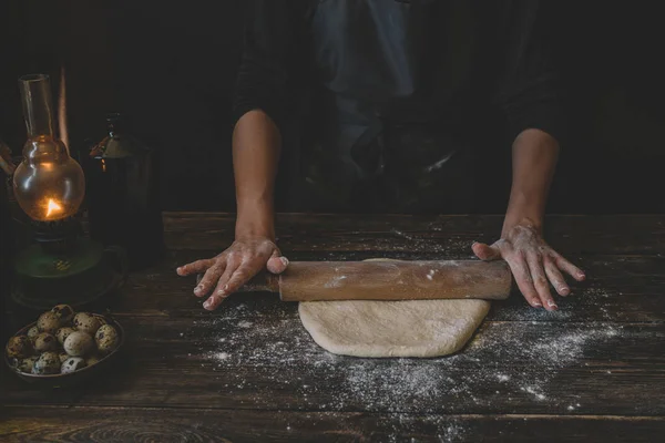 Dough bread, pizza or pie recipe homemade preparation. Female baker hands rolling dough with pin. Food ingredients flat lay on kitchen table. Working with pastry or bakery cooking. Rustic style.