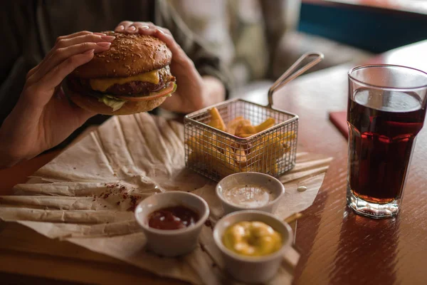 Kobieta Trzyma Burger Frytkami Ręce Tle Kawiarni Burger Świeże Gotowane — Zdjęcie stockowe
