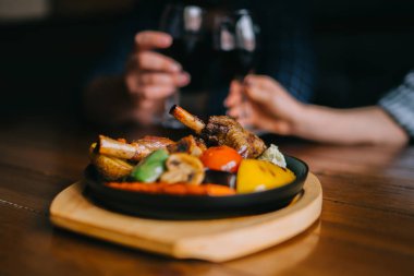 Adam ve kadın gözlük restoranda kırmızı şarap ile kızartma. Şarap bir bardak, seçici odak, bulanıklık. Bir bardak kırmızı şarap. Sommelier şarap cam içine dökme. Şükran günü.