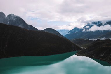 Himalaya Dağları. Dağlar, bulutlar kayalarda gölde. Göl Gokyo RI Everest uzak olmayan görüntüleyin. Renkli manzara güzel kayalar ve dramatik bulutlu gökyüzü. Doğa arka plan.