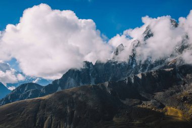 Yüksek dağlar bulutlar mavi gökyüzü ile karlı zirveleri ile. Renkli manzara güzel kayalar ve dramatik bulutlu gökyüzü. Doğa arka plan. Şaşırtıcı dağlar. Seyahat kavramı. Everest bölgesi, Nepal.
