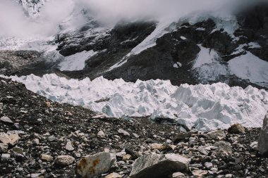 Bir buzul izleri ile keskin gri kayalık tepeler. Himalaya dağ manzarası. Dramatik bulutlar uçurumun altındaki kenarlarını. Doğa arka plan. Nepal Everest Ana kampı trek.
