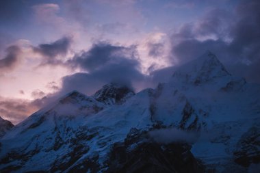 Himalayalar manzara. Dağ silsilesi ile iz sis ve bulutlar, karanlık gökyüzü ile loş Güneş ışığı içinde belgili tanımlık geçmiş. Dağlar fırtınalı havalarda. Himalaya dağlarında, Nepal trekking. Doğa manzara.