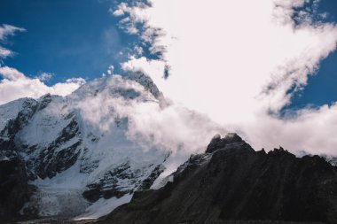 Yüksek dağlar karlı zirveleri parlak güneşli bir günde bulutlara Nepal ile. Renkli manzara güzel kayalar ve dramatik bulutlu gökyüzü. Doğa arka plan. Şaşırtıcı dağlar. Everest yol ana kampta.