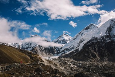 Yüksek dağlar karlı zirveleri parlak güneşli bir günde bulutlara Nepal ile. Renkli manzara güzel kayalar ve dramatik bulutlu gökyüzü. Doğa arka plan. Şaşırtıcı dağlar. Everest yol ana kampta.