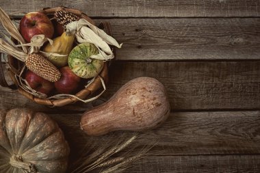 Kabaklar ve buğday ve bascet kırmızı elma ve Mısır ile sonbahar arka plan. Hasat kopya alanı ile yaşında tahta üzerinde kalmaktadır. Mockup mevsimlik teklifler ve tatil kartpostal, en iyi görünüm için. Tonlu görüntü.