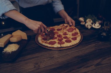 İtalyan tarzı yemek. Ev yapımı pizza domates ve fesleğen ahşap rustik masa ve yemek pişirmek için malzemeler üzerinde kurulu. Şef hazırlanıyor ev yapımı yiyecek eller. Sağlıklı gıdalar, kavram pişirme.