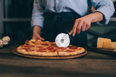 İtalyan tarzı yemek. Ev yapımı pizza domates ve fesleğen ahşap rustik masa ve yemek pişirmek için malzemeler üzerinde kurulu. Şef hazırlanıyor ev yapımı yiyecek eller. Sağlıklı gıdalar, kavram pişirme.
