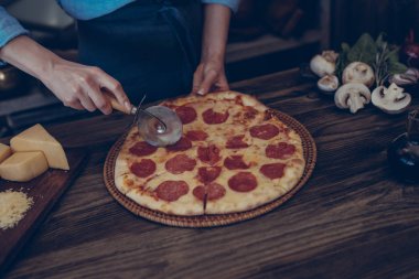 İtalyan tarzı yemek. Ev yapımı pizza domates ve fesleğen ahşap rustik masa ve yemek pişirmek için malzemeler üzerinde kurulu. Şef hazırlanıyor ev yapımı yiyecek eller. Sağlıklı gıdalar, kavram pişirme.