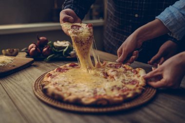 Sıcak biberli pizza, büyük peynir öğle veya akşam yemeği peynir ile dilim. Lezzetli lezzetli lokanta İtalyanca Side'de klasik ahşap tahta masada geleneksel görüntüleyin. Dilim pizza alarak elleriyle.