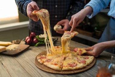 Sıcak biberli pizza, büyük peynir öğle veya akşam yemeği peynir ile dilim. Lezzetli lezzetli lokanta İtalyanca Side'de klasik ahşap tahta masada geleneksel görüntüleyin. Dilim pizza alarak elleriyle.