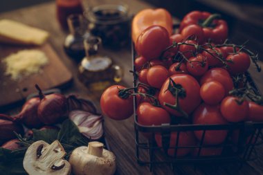 Gıda katkı maddeleri ve yemek pişirmek için baharat. Mantar, domates, peynir, soğan, yağ, biber, tuz, fesleğen, zeytinyağı. rustik ahşap arka plan üzerinde. Sağlıklı gıdalar, kavram yemek. Tonlu görüntü.