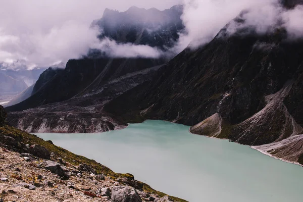 Himalayas mountains. Lake in the mountains, rocks in clouds. View on the lake Gokyo Ri not far from Everest. Colorful landscape with beautiful rocks and dramatic cloudy sky. Nature background.