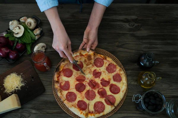 クックの手をテーブルの上の自家製ピザを作る ピザ食材を使用 トマト ニンニク パセリ コショウ 暗い背景の木のパルメザン チーズ 食べ物 家族や人々 — ストック写真