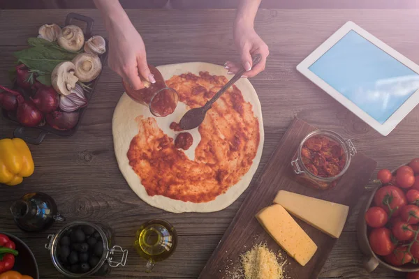 The young woman looking recipe in a tablet computer in kitchen. Healthy food. Healthy lifestyle. Cooking at home. Cooking according to recipe on tablet screen. Technology concept. Toned image.