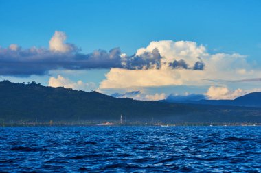 Güzel manzara dağ ve göl vardır. Göl üzerinde harika bir manzara. Dramatik ve güzel sahne. Arka planda güzel dağları ile göl kenarında küçük bir köy görüntüleyin. Tatil ve seyahat kavramı
