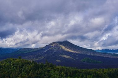 Arka plan seyahat. Kırsal gündoğumu manzara. Kırsal ve yeşil tropikal orman. Doğal arka plan. Manzara Batur yanardağ Bali Adası, Endonezya. Dramatik gökyüzü bulutlu Dağları.