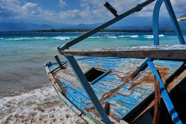 Eski güzel tropikal plaj ahşap tekne güneşli bir günde masmavi berrak su arka plan üzerinde terk edilmiş. Deniz manzaralı muhteşem doğa arka plan. Su ve güzel parlak renk.