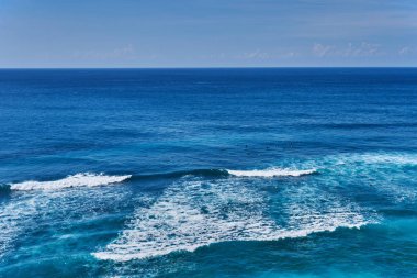 Üstten görünüm sörfçü turkuaz okyanusun yüzeyinde büyük dalgalar bulutsuz bir günde bekliyor. Deniz su arka plan. Tropikal okyanus sörf harika dalga su. Yaz tatil ve seyahat kavramı macera.