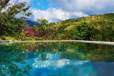 Tatil günlerinde güzel lüks resort. Tropikal otel yüzme havuzunda. Güzel etkileyici bir doğa geçmiş. Tropikal yeşil ağaçlar ve çiçekler. Lüks tatil. Seyahat ve tatil kavramı.