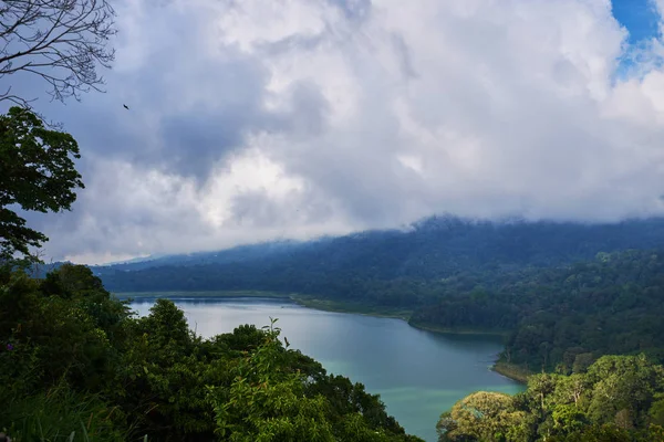 一座被火山山脉包围的湖泊 天空中有戏剧性云彩的热带景观 从山上看湖和山景 湖岸边的森林 自然背景 — 图库照片