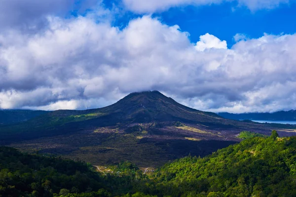 Beautiful banner with mountain landscape and tropical forest. Landscape of Batur volcano on Bali island, Indonesia. View far away beauty, inspiring mountain, fresh blue sky. Summer day.