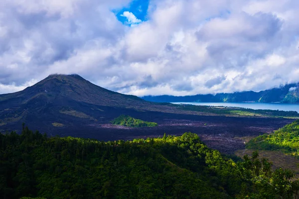 Beautiful banner with mountain landscape and tropical forest. Landscape of Batur volcano on Bali island, Indonesia. View far away beauty, inspiring mountain, fresh blue sky. Summer day.