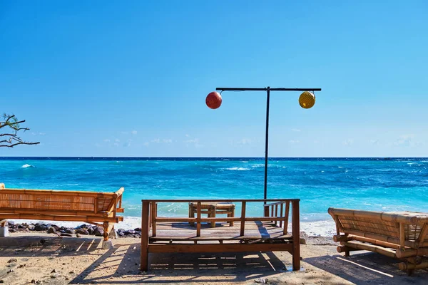 Wooden lounge bed for relaxing on the paradise beach. Tropical recreational for vacation. Summer morning ocean view. Tropical sea resort beach serene scene. Relaxing atmosphere. Travel concept.