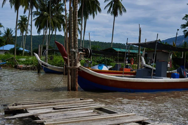 Boats parked in fishing village. Fisherman village. Many fishing boats moored at old wooden pier. Traditional thai fisherman long tail boat in a fishermen village, Thailand, Asia.