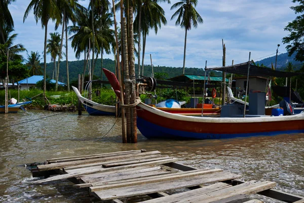 Boats parked in fishing village. Fisherman village. Many fishing boats moored at old wooden pier. Traditional thai fisherman long tail boat in a fishermen village, Thailand, Asia.