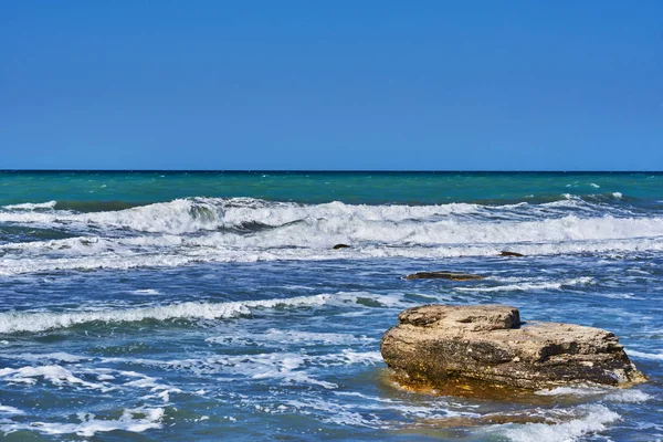 騒々しいと美しい海の風景泡波 石の海岸 ターコイズ ブルーの海の方を見る 海は満潮の間にサーフィンします 泡で海辺の波 夏の休日 旅行の概念 — ストック写真