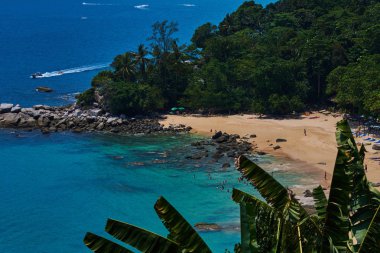 Yüksek doğal güzel manzara plaj görüntüleyin. Okyanus kıyısında, kumlu plaj derin sularda yüzme insanlarla dolu. Palmiye ağaçları ve küçük okyanus bir güneşli yaz gününde defne.