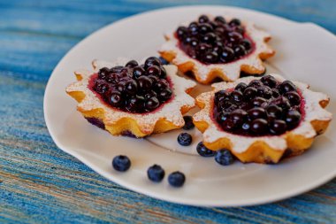 Yavaşça berry reçel ile hafif hamur tartlets tabakta servis yemek, trendy bir kafede mutfakta bir lezzetli tatlı tatlı duruyor