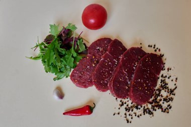 Pürüzsüz, taze et yanında biftek kesilmiş beyaz bir masaya en satın alma taze sebze salatası yaptı