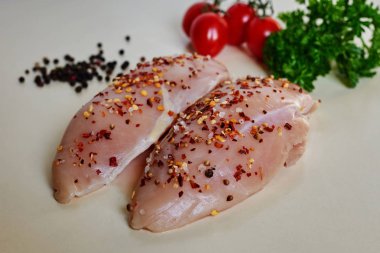 Çiğ çiğ tavuk fileto yemek için-malzemeler bir kesme masada sarımsak, biber, domates, otlar ve hakkındaki. Diyet, sağlıklı düşük kalorili gıda, kavramı kaybetmek ağırlık. Seçici odak.